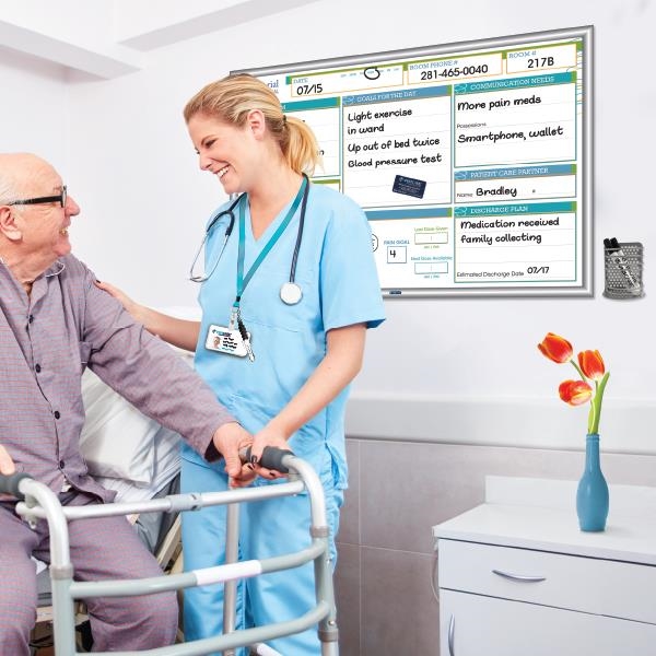 nurse and patient in hospital room with custom white board featuring matching silver white board edge and silver marker holder mounted to wall