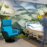 Nurse in patient room with mural and custom patient information board