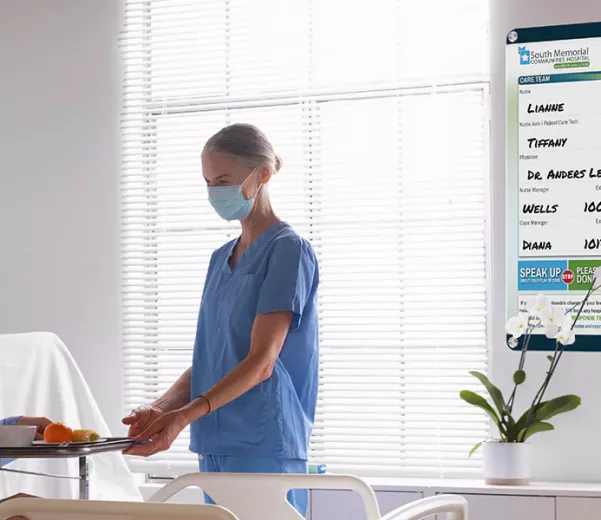 nurse and patient in patient room with custom quick change patient board in VisiCare Plexi Board interchangeable board style
