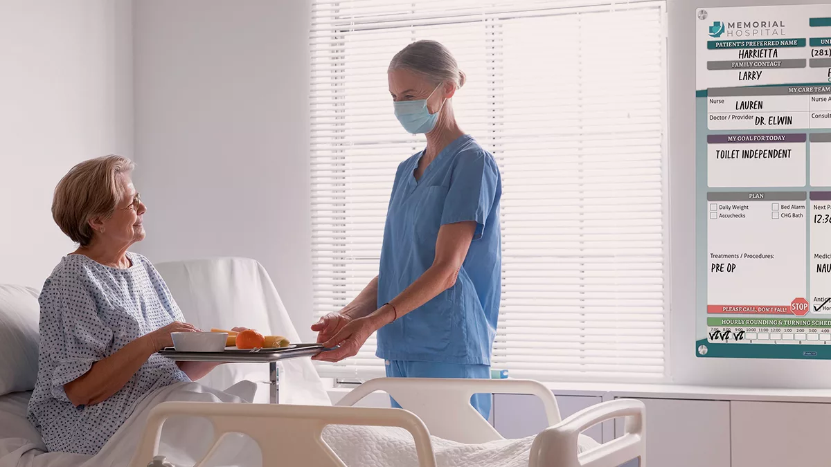 Nurse and patient talk in environment of care with custom patient glass whiteboard