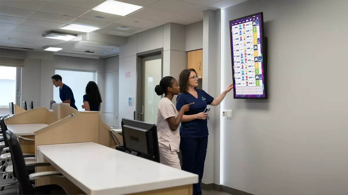 Nurse manager and RN look at Nurse Unit electronic board from VisiCareHD Digital Boards