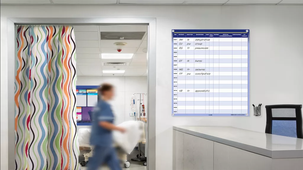 Nurse resets a pediatric patient room with custom patient board for large hospital with custom nurse unit boards at nurse station