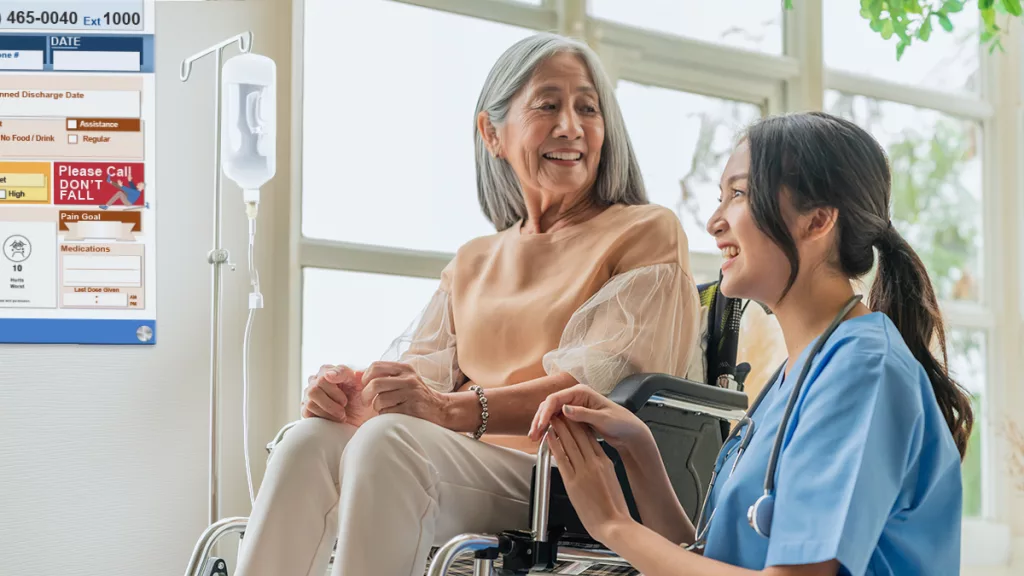 Nurse and patient discuss care using the custom patient board in the hospital patient room