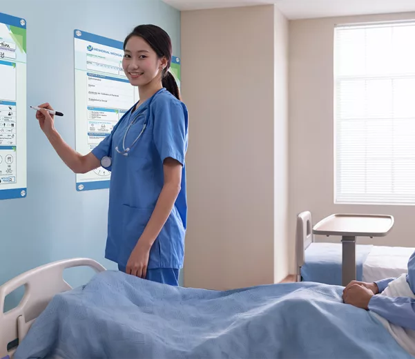 Nurse discusses patient care with patient giving 5 star experience with custom patient board in glass board style